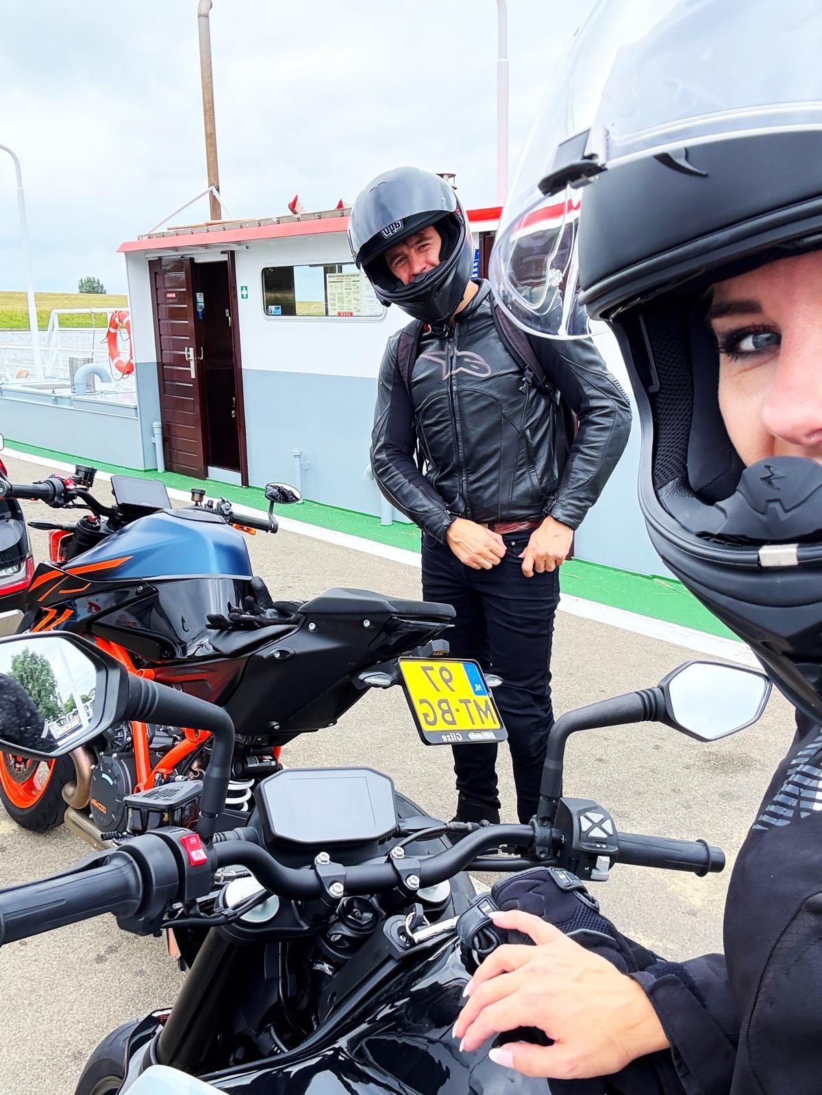Selfie met helm op een veerpont, een andere motorrijder staat bij de motoren