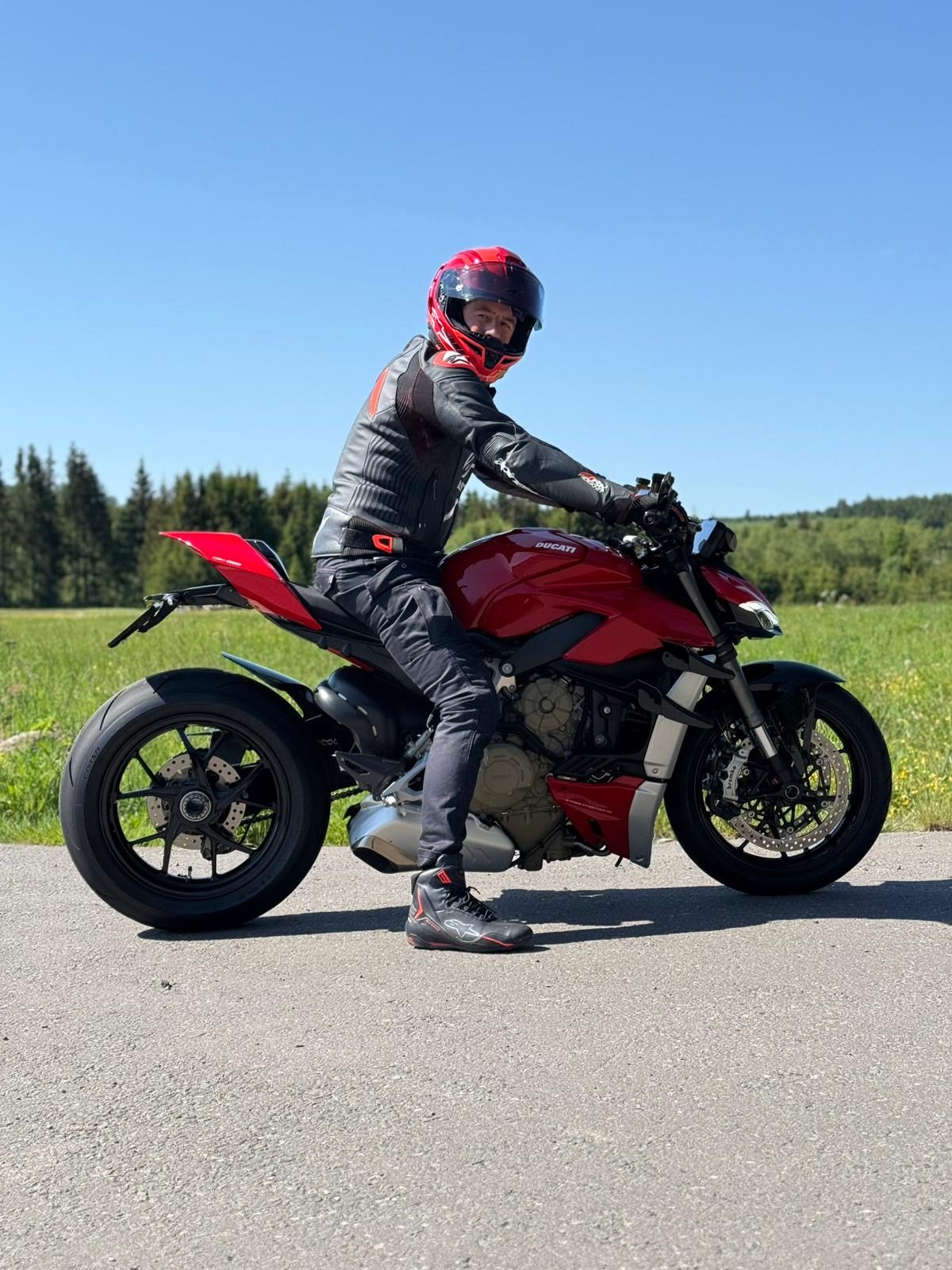 Motorrijder op een rode motor, klaar om te vertrekken