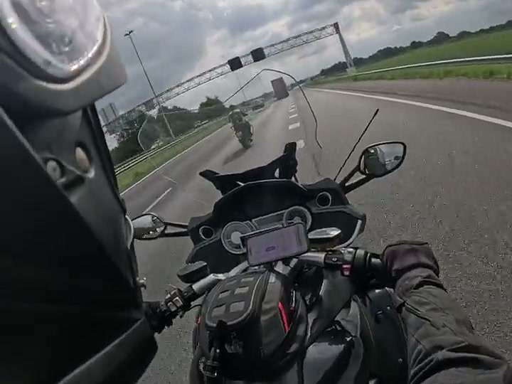 Leerling rijdt over de snelweg, gefilmd vanaf de motor van de instructeur